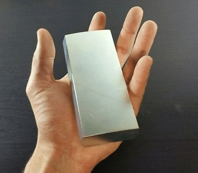 Silný voľne dostupný neodýmový magnet v ruke človeka